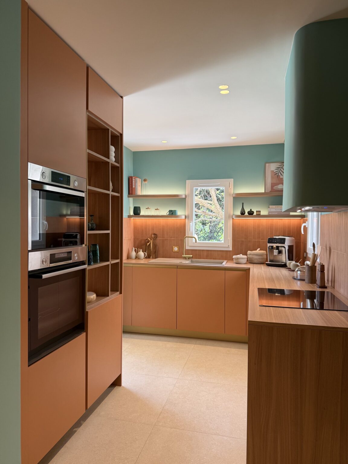 Cuisine sur mesure terracotta et bois avec hotte arrondie verte – projet Favorita