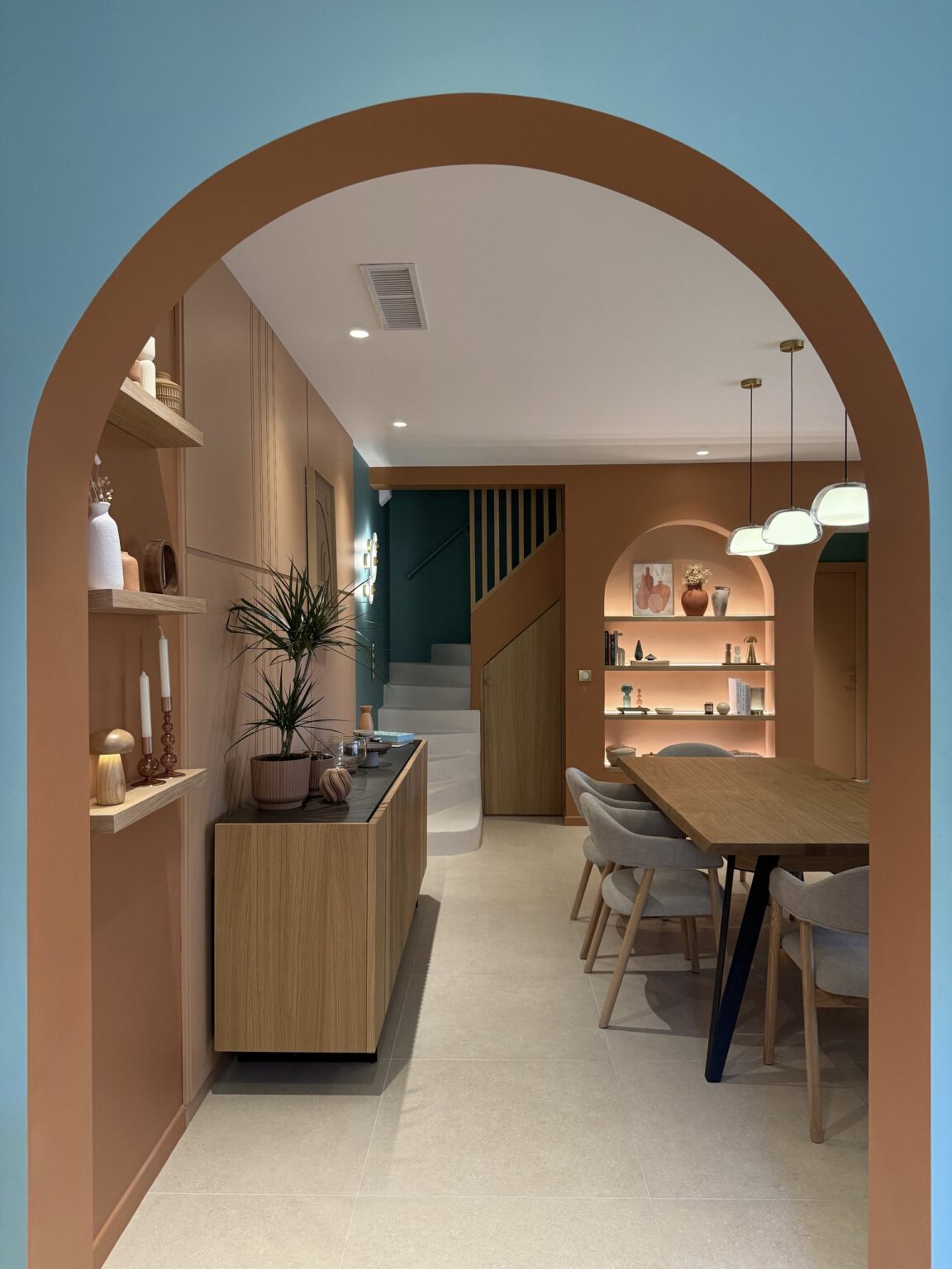 Arche bleue ouvrant sur la salle à manger et la niche éclairée – projet Favorita