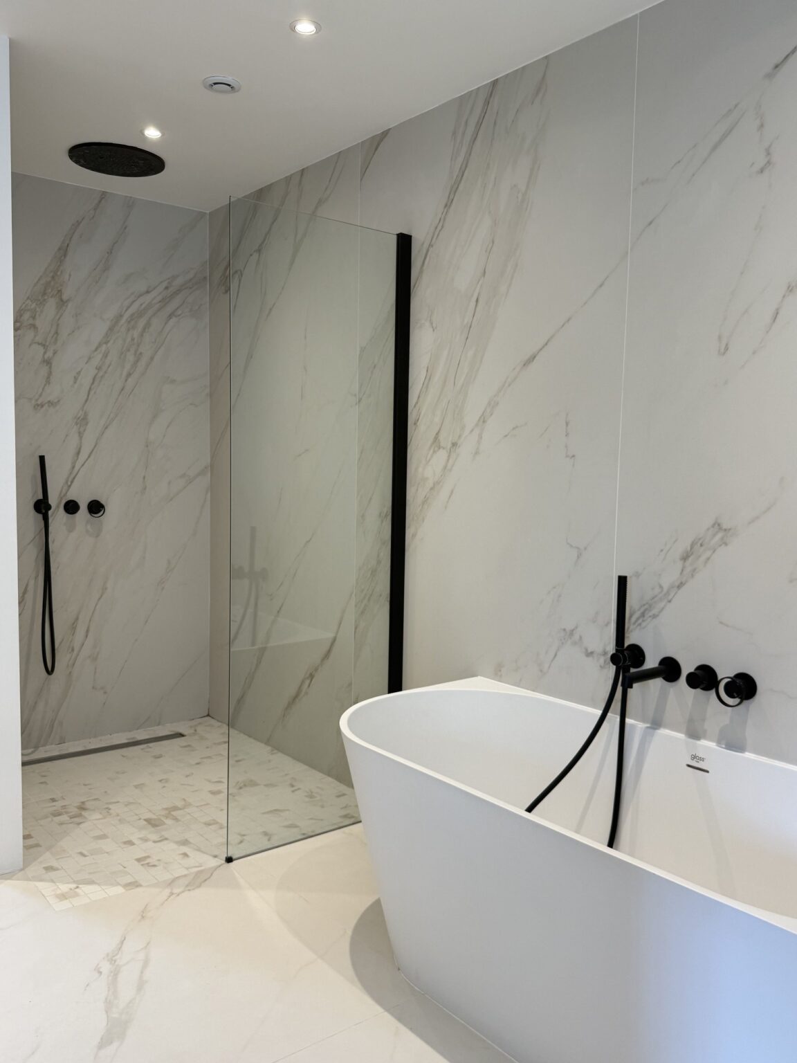 Salle de bain en marbre avec baignoire îlot et douche à l'italienne – villa Nova à Vence